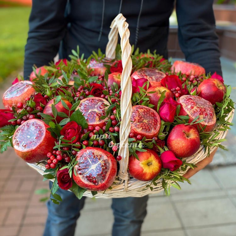 Корзина гранатов и яблок с брусникой (крупный план)