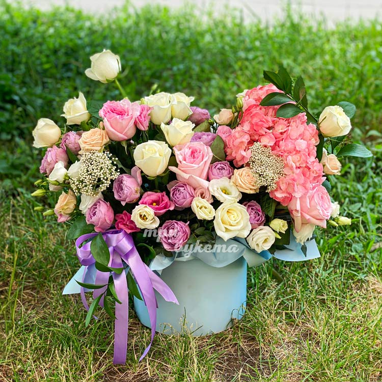 Шляпная коробка роз, эустом и гортензии (на фоне зеленый травы)