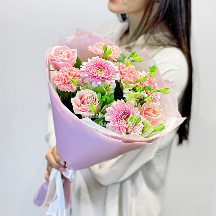 Букет розовых гербер, гвоздик и роз (в руках флориста)